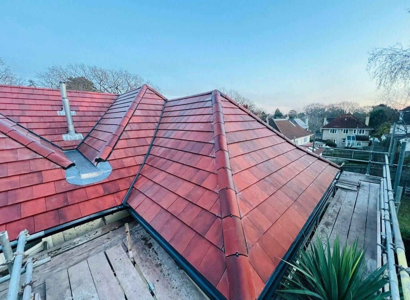 Completed red clay plain tile hipped roof in Canterbury with lead flashed vent pipes