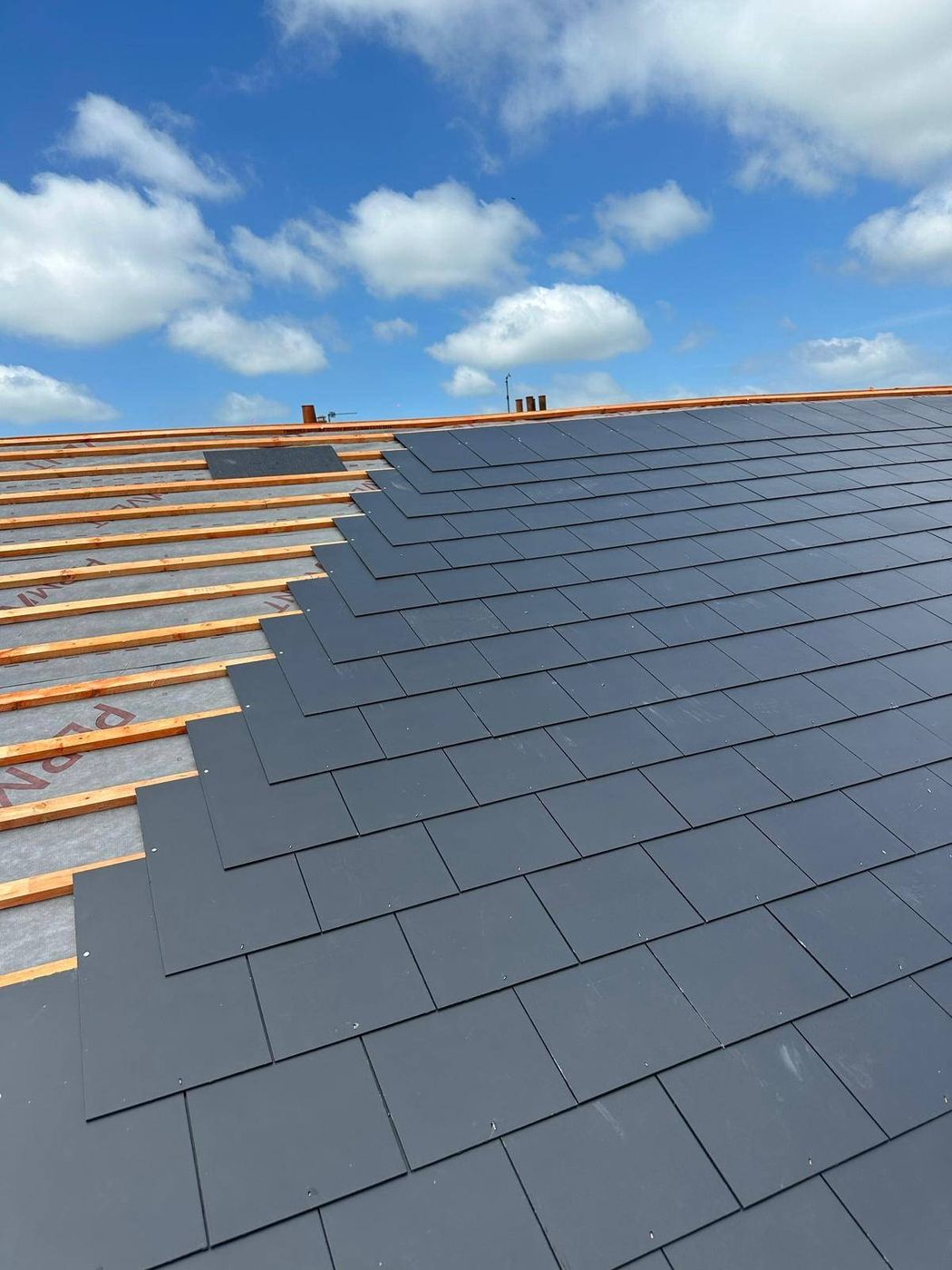 Natural slate being laid in progress on a Canterbury roof slope