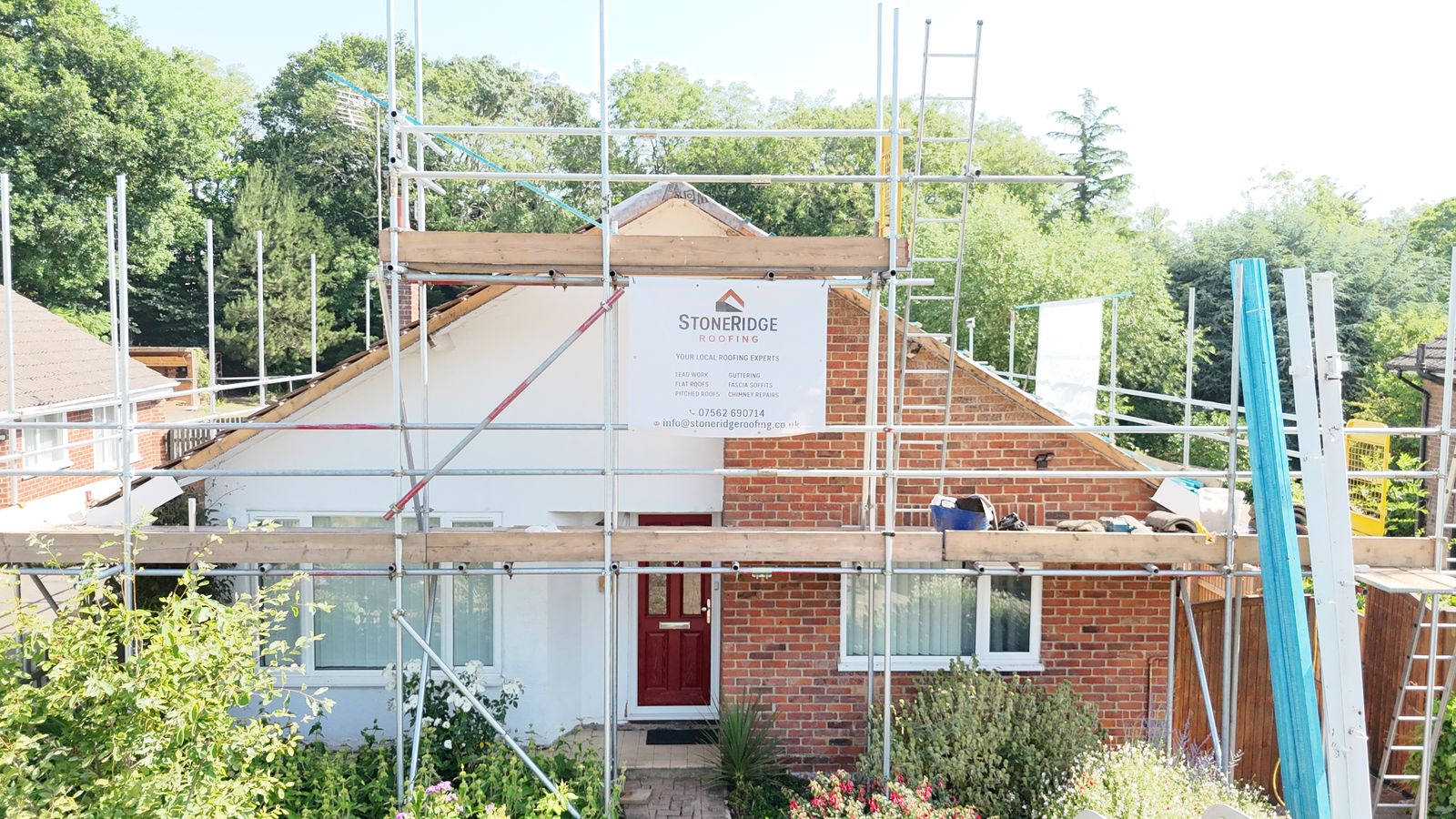 Canterbury bungalow with full scaffold and a StoneRidge Roofing board before the re-roof