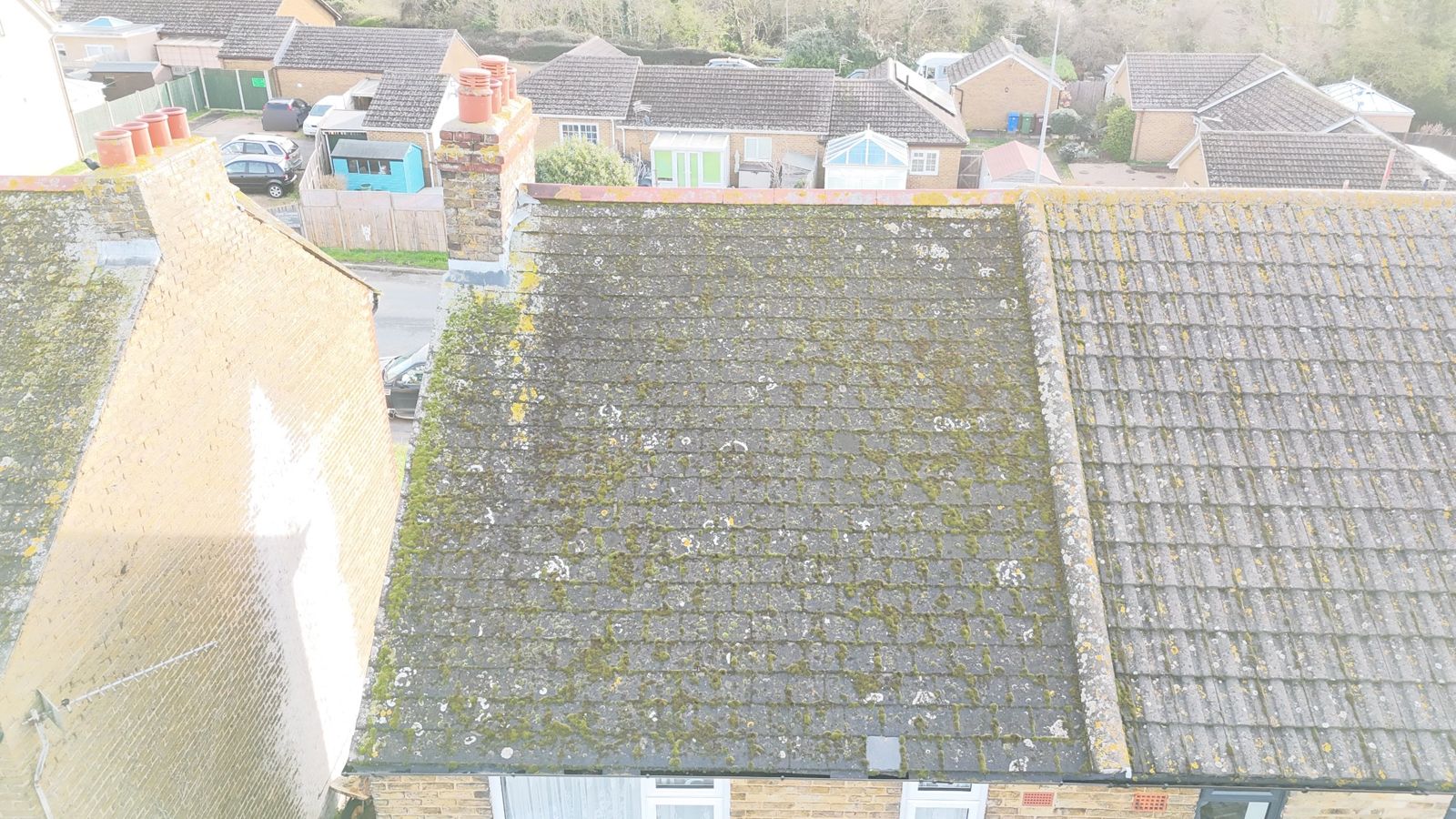 Rear slope of the same roof before work, covered in moss and lichen