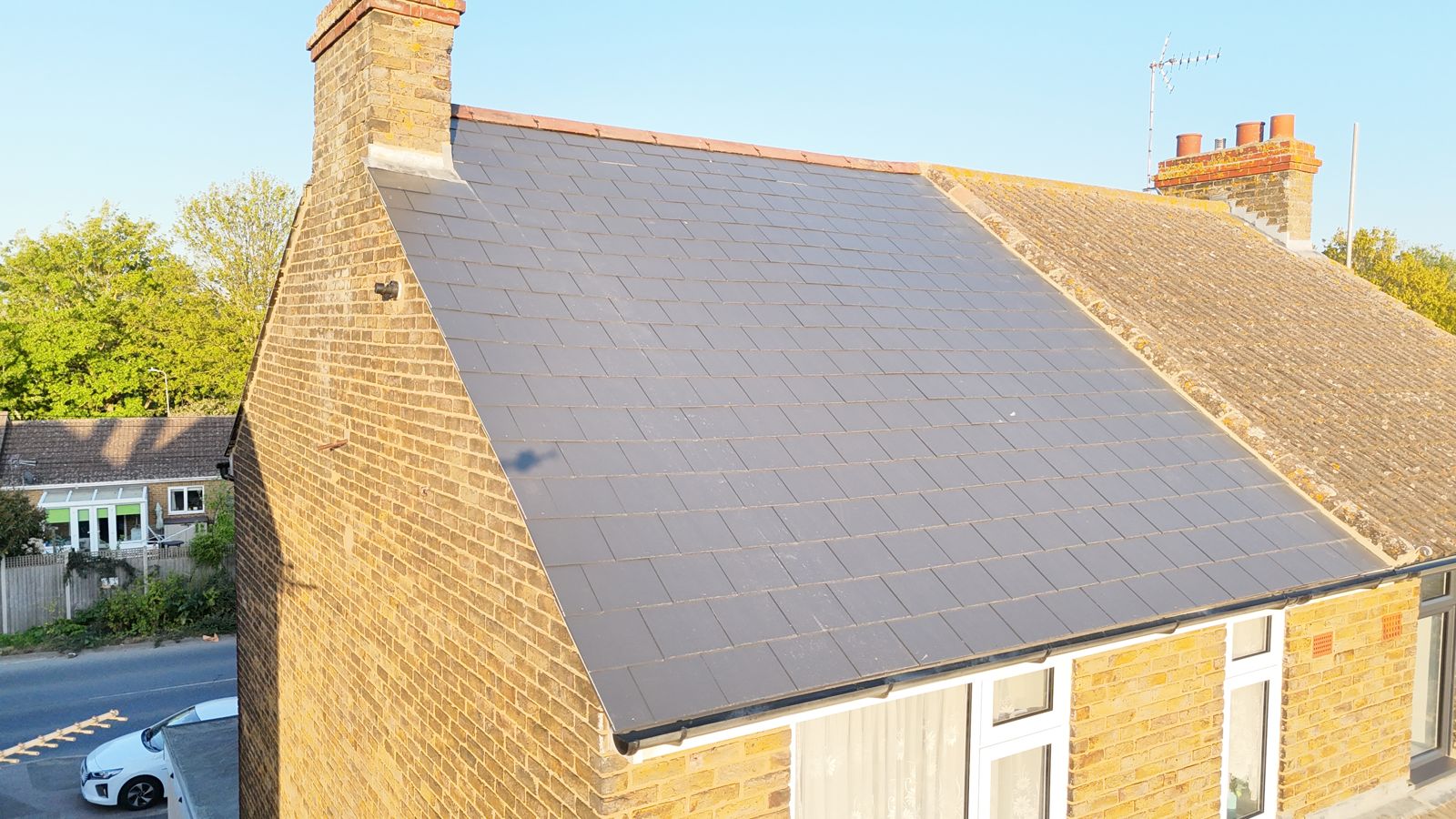 Finished new slate roof on one half of a semi-detached house near Sittingbourne, original ridge refitted