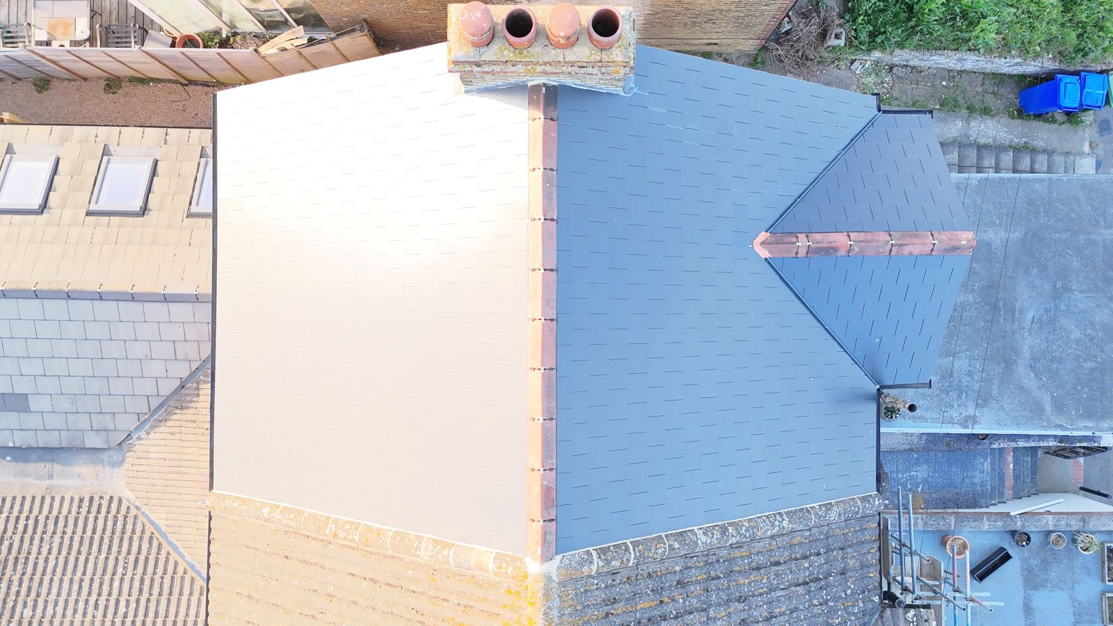 Top-down drone view of the finished slate roof including the rear slope and front gable